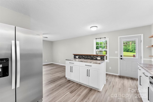 103A N Tracy St, Kings Mountain, NC 28086 - kitchen featuring stainless steel refrigerator with ice dispenser, light wood-style floors, white cabinetry, baseboards, and light stone countertops