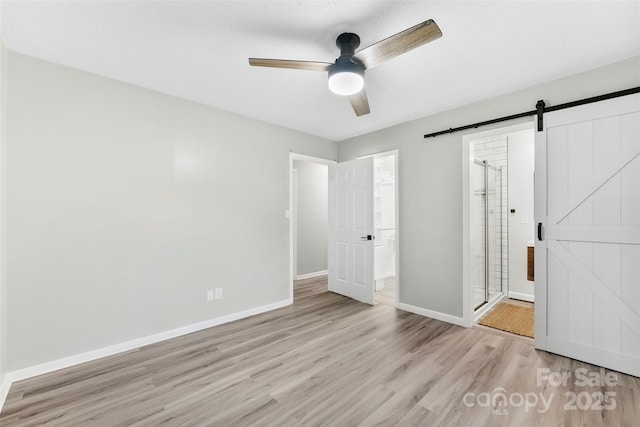 103A N Tracy St, Kings Mountain, NC 28086 - unfurnished bedroom featuring a barn door, wood finished floors, baseboards, connected bathroom, and ceiling fan