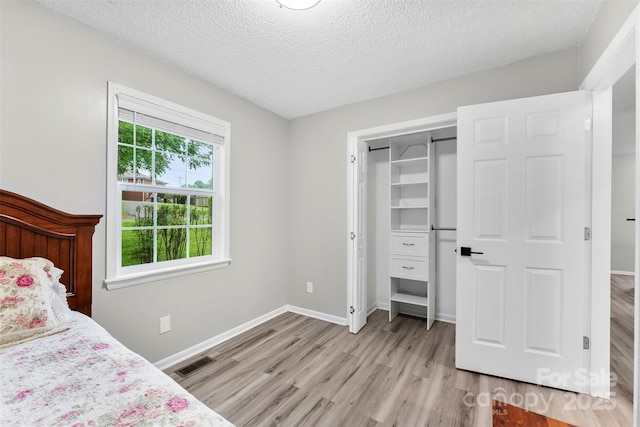 103A N Tracy St, Kings Mountain, NC 28086 - bedroom featuring light wood-style flooring, a textured ceiling, baseboards, and a closet