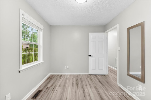 103A N Tracy St, Kings Mountain, NC 28086 - unfurnished bedroom with light wood-type flooring, a textured ceiling, and baseboards