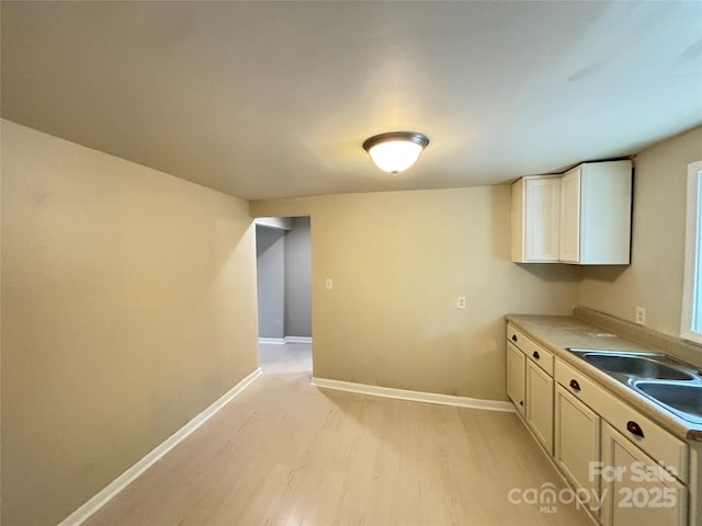 502 E Main St, Cleveland, NC 27013 - kitchen with light wood finished floors, a sink, and baseboards