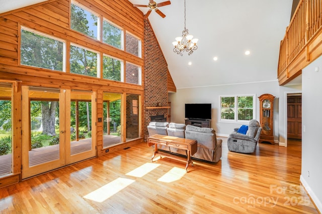 6350 Mount Pleasant Rd S, Concord, NC 28025 - living area with high vaulted ceiling, a fireplace, a chandelier, light wood-style floors, and ceiling fan