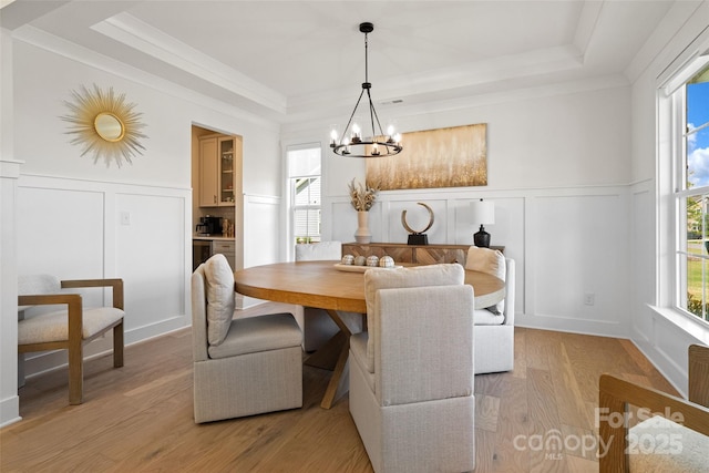433 Sinaloa St, Waxhaw, NC 28173 - dining room with a decorative wall, a raised ceiling, a chandelier, light wood-style floors, and a wainscoted wall