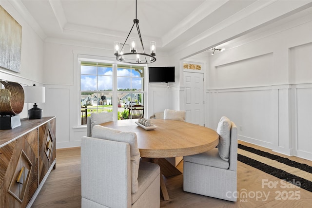 433 Sinaloa St, Waxhaw, NC 28173 - dining space featuring a decorative wall, a chandelier, a raised ceiling, wainscoting, and ornamental molding