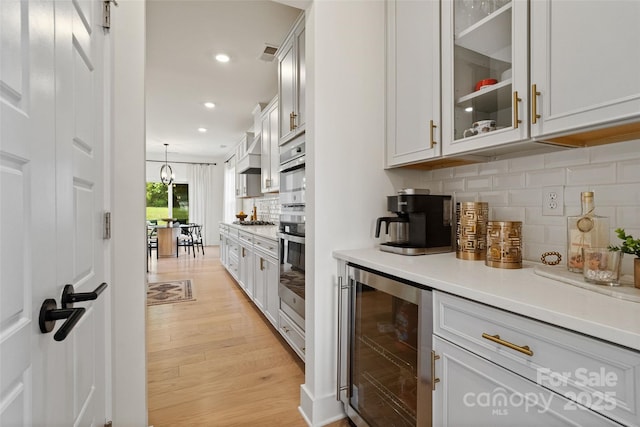 433 Sinaloa St, Waxhaw, NC 28173 - bar area featuring wine cooler, light wood-style floors, tasteful backsplash, recessed lighting, and pendant lighting