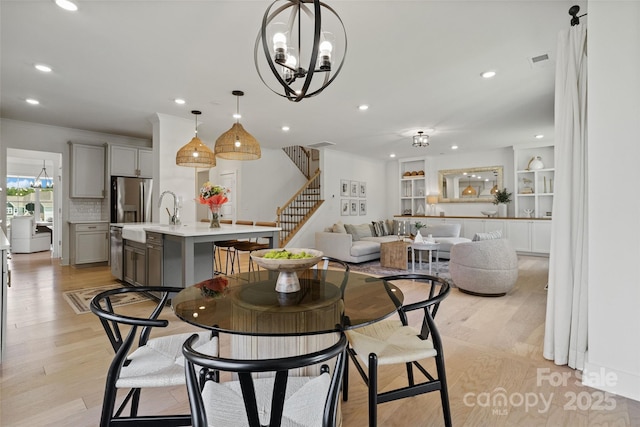 433 Sinaloa St, Waxhaw, NC 28173 - dining space featuring stairway, recessed lighting, a chandelier, light wood-type flooring, and crown molding