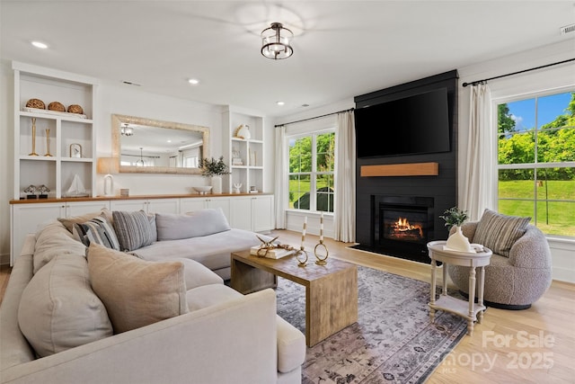 433 Sinaloa St, Waxhaw, NC 28173 - living room featuring wood finished floors, a large fireplace, and built in shelves