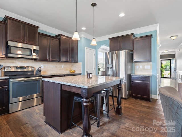 1810 Kerwick Ct, Lancaster, SC 29720 - kitchen featuring stainless steel appliances, ornamental molding, arched walkways, dark brown cabinetry, and recessed lighting