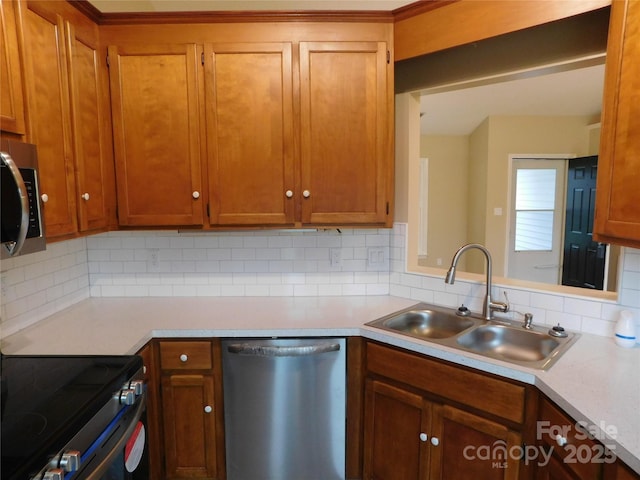 3001 Austin Chaney Rd, Monroe, NC 28110 - kitchen with appliances with stainless steel finishes, a sink, light countertops, decorative backsplash, and brown cabinets