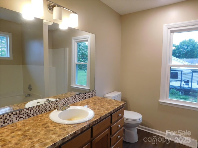 3001 Austin Chaney Rd, Monroe, NC 28110 - bathroom with toilet, vanity, a tub to relax in, wood finished floors, and baseboards