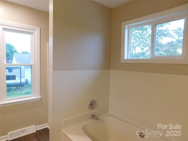 3001 Austin Chaney Rd, Monroe, NC 28110 - bathroom with healthy amount of natural light, a bath, baseboards, and wood finished floors