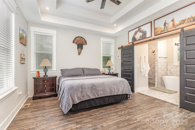 5215 Star Magnolia Ct, Clover, SC 29710 - bedroom with a barn door, wood finished floors, a tray ceiling, and recessed lighting