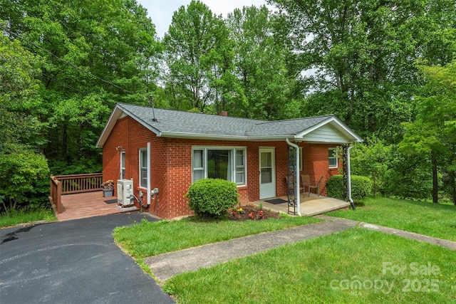 1788 Blue Rock Rd, Burnsville, NC 28714 - view of front of house with a porch, brick siding, a front yard, a shingled roof, and a cooling unit