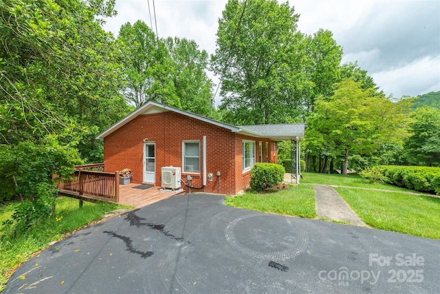 1788 Blue Rock Rd, Burnsville, NC 28714 - view of front facade with brick siding, a deck, a cooling unit, a front yard, and driveway