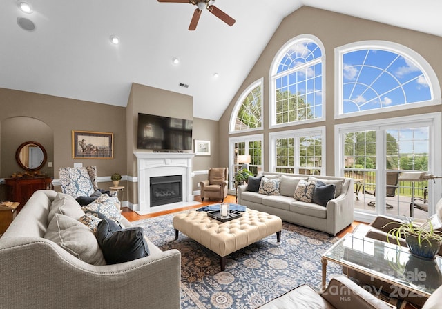 7412 Sahalee Dr, Denver, NC 28037 - living area featuring wood finished floors, ceiling fan, high vaulted ceiling, plenty of natural light, and a fireplace with flush hearth