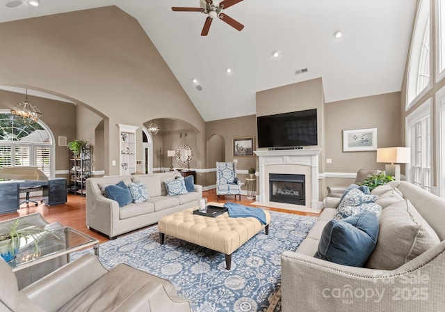 7412 Sahalee Dr, Denver, NC 28037 - living area featuring arched walkways, high vaulted ceiling, a chandelier, wood finished floors, and a ceiling fan