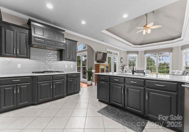 7412 Sahalee Dr, Denver, NC 28037 - kitchen with a sink, dark cabinetry, stainless steel gas cooktop, ceiling fan, and arched walkways