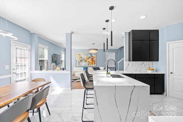 2213 Iron Works Dr, Clover, SC 29710 - kitchen with dark cabinetry, light marble finish flooring, modern cabinets, a kitchen bar, and recessed lighting