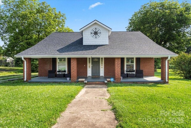 85 Ruritan Park Rd, Stony Point, NC 28678 - view of front of house featuring covered porch, a front lawn, roof with shingles, an outdoor hangout area, and brick siding