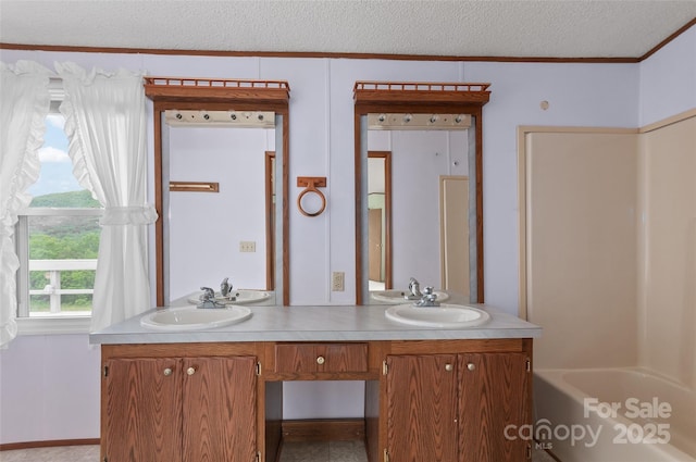 112 Melody St, Clyde, NC 28721 - bathroom featuring crown molding, double vanity, a textured ceiling, and bathtub / shower combination