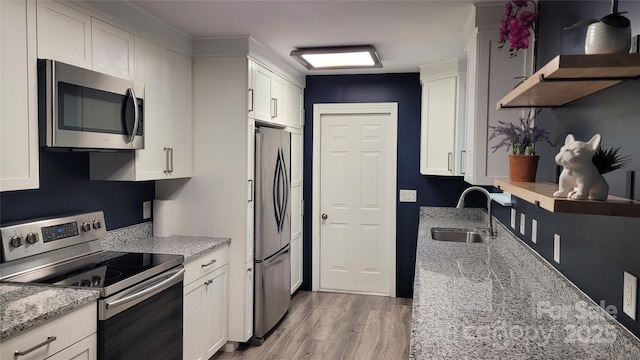 109 Pepper Cir, Mooresville, NC 28117 - kitchen featuring stainless steel appliances, a sink, light wood finished floors, white cabinetry, and light stone counters