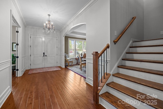 3009 Botetourt Ct, Weddington, NC 28104 - entrance foyer with arched walkways, crown molding, wood finished floors, a chandelier, and stairway