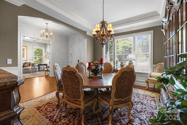 3009 Botetourt Ct, Weddington, NC 28104 - dining space featuring a chandelier, arched walkways, wood finished floors, ornamental molding, and wainscoting