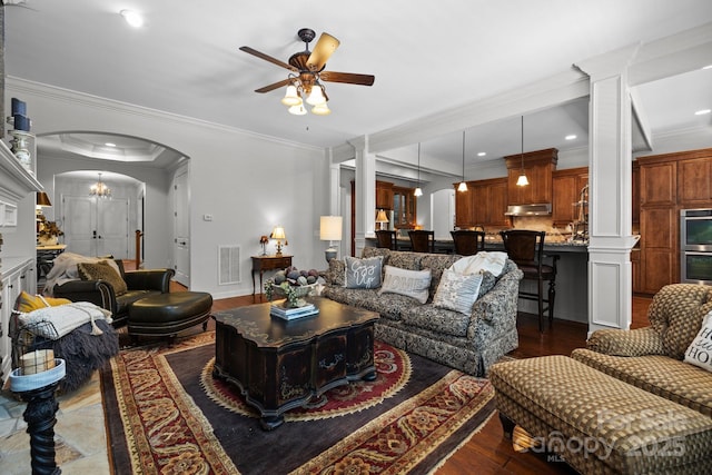3009 Botetourt Ct, Weddington, NC 28104 - living area with arched walkways, ceiling fan, dark wood-style floors, ornate columns, and ornamental molding