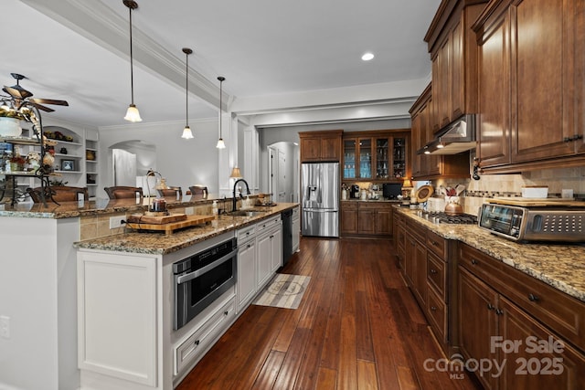 3009 Botetourt Ct, Weddington, NC 28104 - kitchen with appliances with stainless steel finishes, arched walkways, under cabinet range hood, a ceiling fan, and glass insert cabinets