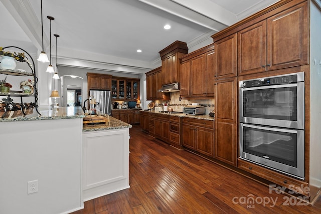 3009 Botetourt Ct, Weddington, NC 28104 - kitchen featuring stainless steel appliances, arched walkways, light stone countertops, dark wood-style floors, and decorative light fixtures