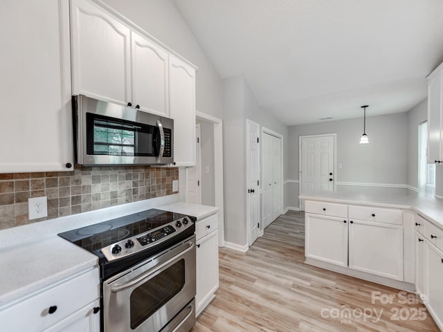 10736 Spruce Mountain Rd, Charlotte, NC 28214 - kitchen featuring appliances with stainless steel finishes, tasteful backsplash, white cabinets, a peninsula, and light countertops