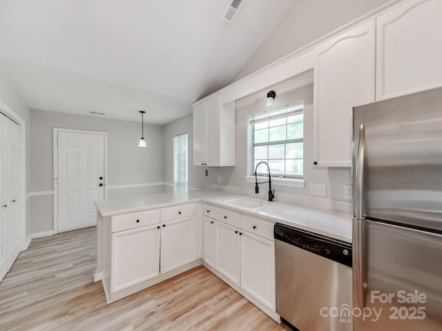 10736 Spruce Mountain Rd, Charlotte, NC 28214 - kitchen with appliances with stainless steel finishes, a sink, a peninsula, white cabinetry, and light wood-style flooring