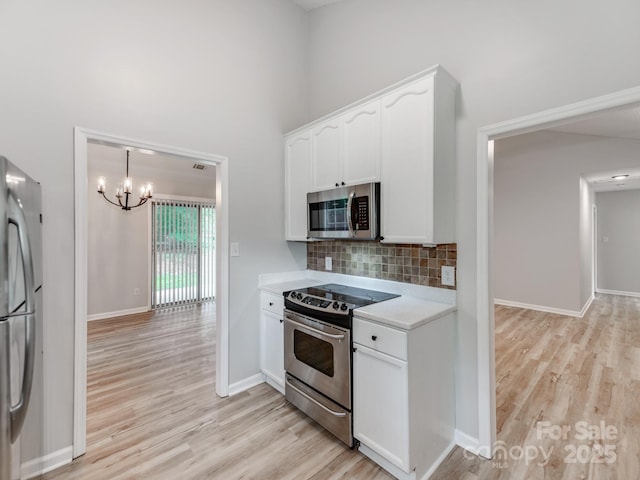 10736 Spruce Mountain Rd, Charlotte, NC 28214 - kitchen featuring stainless steel appliances, light wood-style floors, a chandelier, light countertops, and a towering ceiling