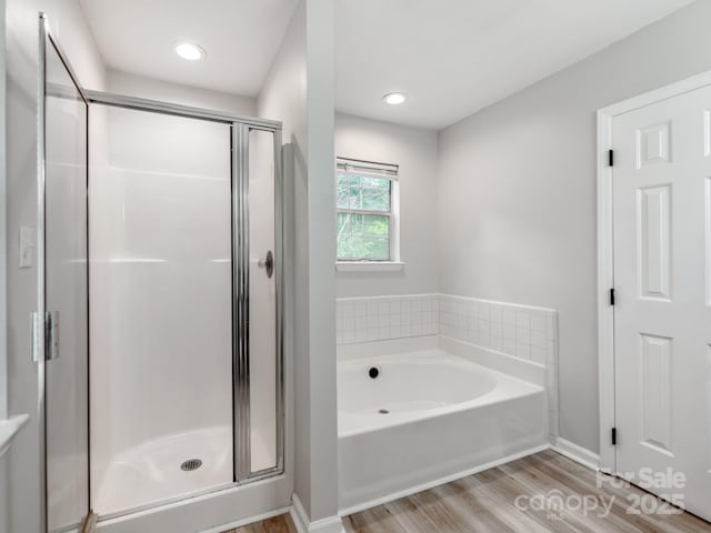 10736 Spruce Mountain Rd, Charlotte, NC 28214 - bathroom featuring a stall shower, a bath, wood finished floors, and baseboards