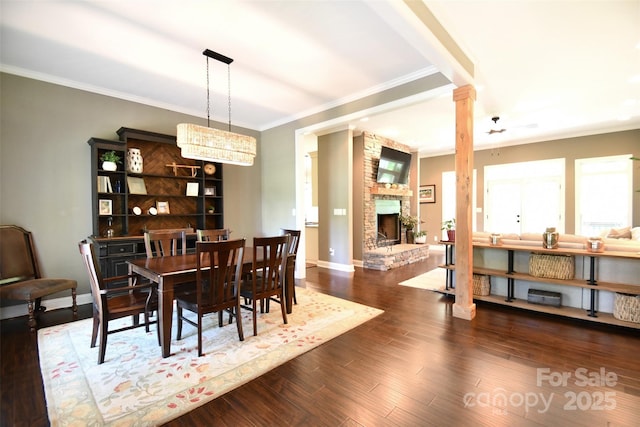 114 Wingard Rd, Concord, NC 28025 - dining area featuring decorative columns, crown molding, a stone fireplace, wood finished floors, and baseboards