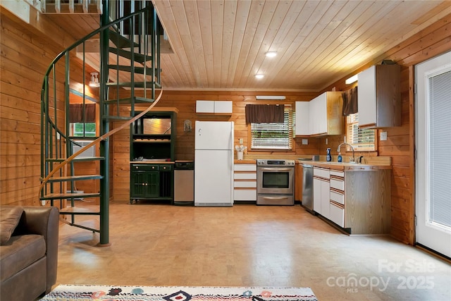 261 Franks Cove Rd, Brevard, NC 28712 - kitchen featuring stainless steel appliances, wood walls, wooden ceiling, light countertops, and white cabinets