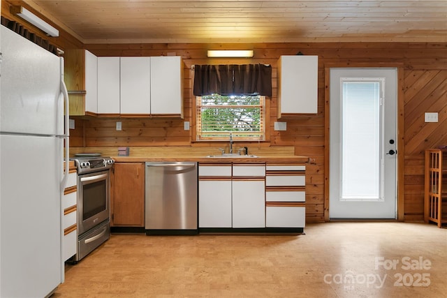 261 Franks Cove Rd, Brevard, NC 28712 - kitchen featuring appliances with stainless steel finishes, a sink, wooden walls, white cabinets, and wooden ceiling