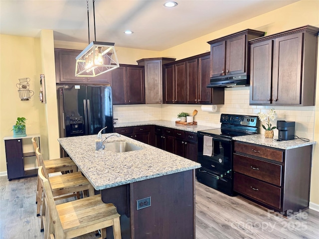750 Fraternity Row, Kannapolis, NC 28081 - kitchen with black appliances, under cabinet range hood, a sink, dark brown cabinets, and light stone counters