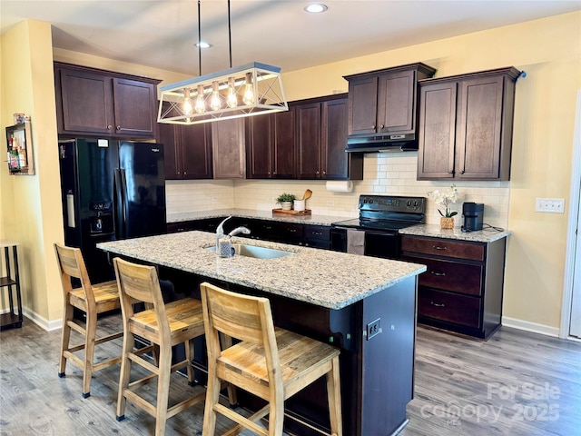750 Fraternity Row, Kannapolis, NC 28081 - kitchen featuring a sink, black appliances, under cabinet range hood, dark brown cabinetry, and light stone counters