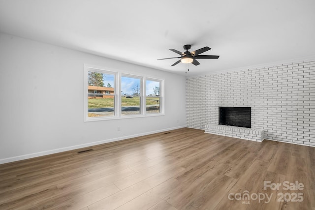 5520 Chestnut Dr, Hickory, NC 28602 - unfurnished living room with a brick fireplace, a ceiling fan, wood finished floors, and baseboards