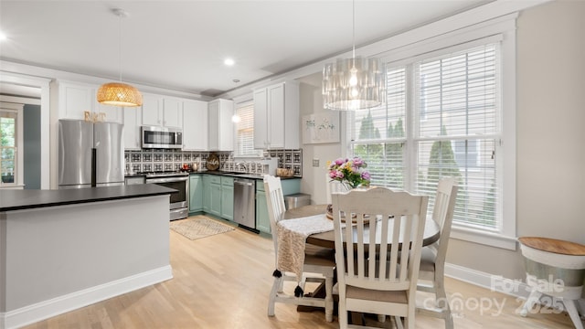 6129 Caseys Side Way, Fort Mill, SC 29708 - kitchen featuring stainless steel appliances, dark countertops, decorative backsplash, light wood-style floors, and plenty of natural light