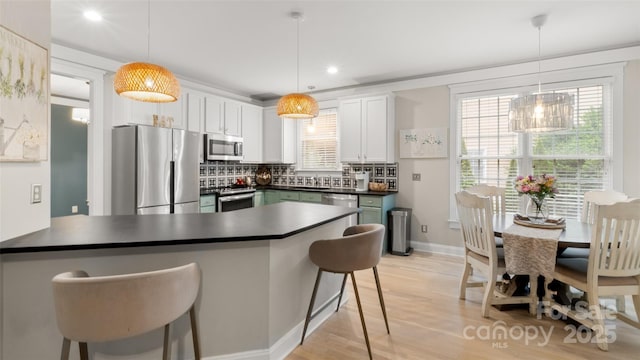 6129 Caseys Side Way, Fort Mill, SC 29708 - kitchen with appliances with stainless steel finishes, a peninsula, dark countertops, recessed lighting, and a kitchen bar
