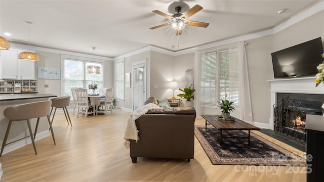 6129 Caseys Side Way, Fort Mill, SC 29708 - living area with light wood-type flooring, a ceiling fan, crown molding, a lit fireplace, and baseboards