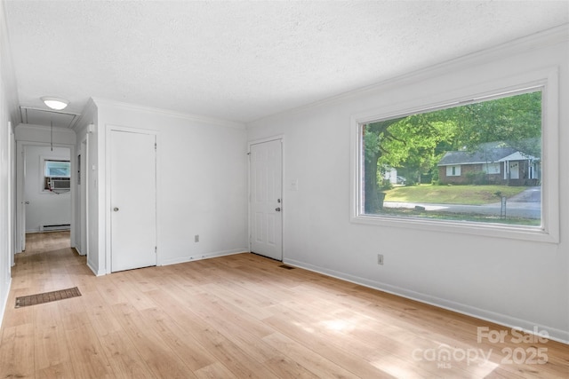 1310 Caldwell St, Greensboro, NC 27406 - empty room with a textured ceiling, a baseboard radiator, attic access, light wood-style floors, and crown molding