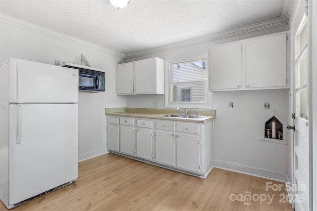 1310 Caldwell St, Greensboro, NC 27406 - kitchen featuring freestanding refrigerator, a sink, light wood finished floors, light countertops, and crown molding