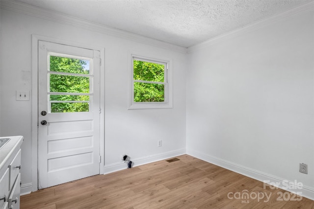 1310 Caldwell St, Greensboro, NC 27406 - entryway with plenty of natural light, ornamental molding, light wood-style flooring, a textured ceiling, and baseboards