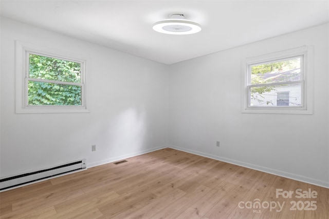 1310 Caldwell St, Greensboro, NC 27406 - empty room featuring light wood-type flooring, baseboards, and a baseboard radiator
