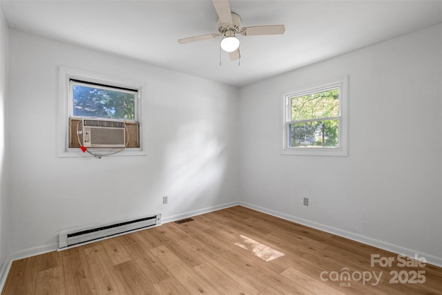 1310 Caldwell St, Greensboro, NC 27406 - empty room featuring a baseboard heating unit, healthy amount of natural light, cooling unit, and light wood-style flooring