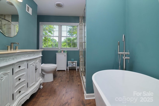 2618 Pineview Dr, Lancaster, SC 29720 - bathroom with vanity, a stall shower, a freestanding bath, wood finished floors, and toilet