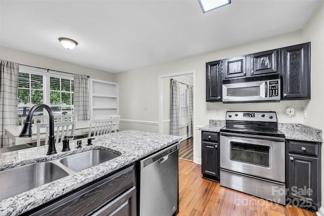 2005 Schofield Pl, Salisbury, NC 28144 - kitchen with appliances with stainless steel finishes, a sink, light wood-type flooring, and light stone counters